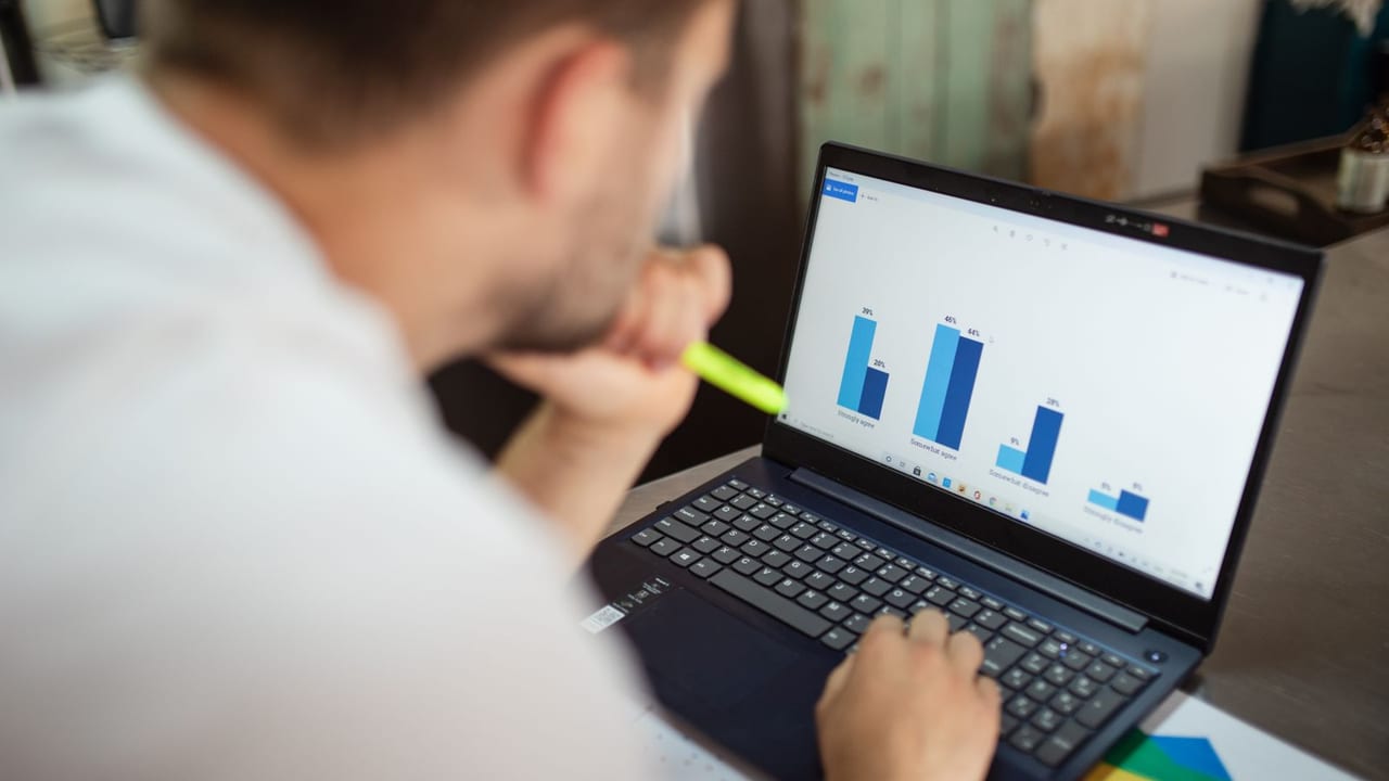 Configuration and reporting charts open on a laptop.