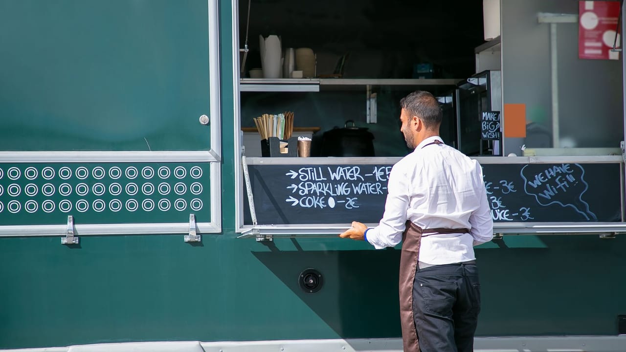 Operator opening up the service window of a food truck.