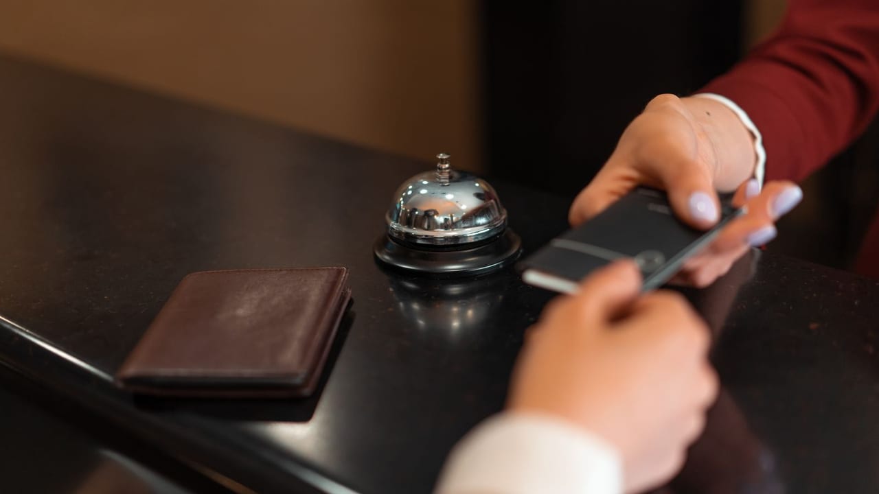 Guest signing for a charge with a room key card in hand.